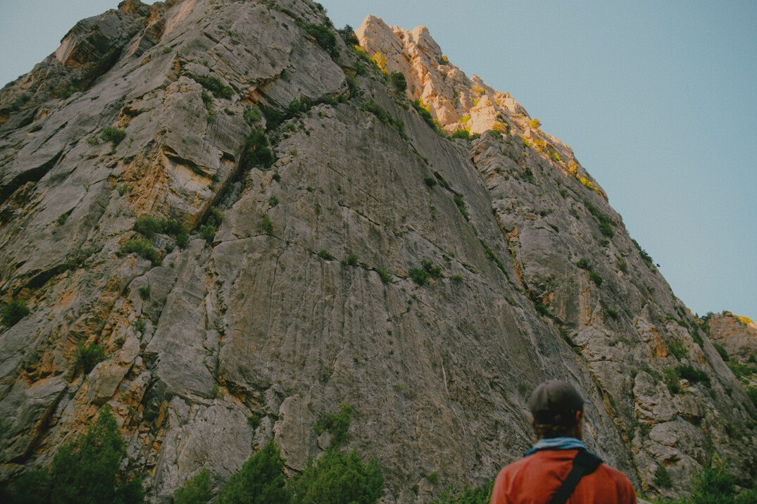 person climbing mountain peak